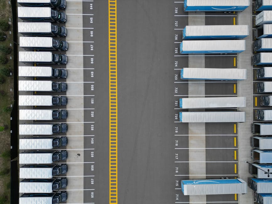 Top-down view of lined-up trucks at a logistics parking lot, showing organized transportation hub.